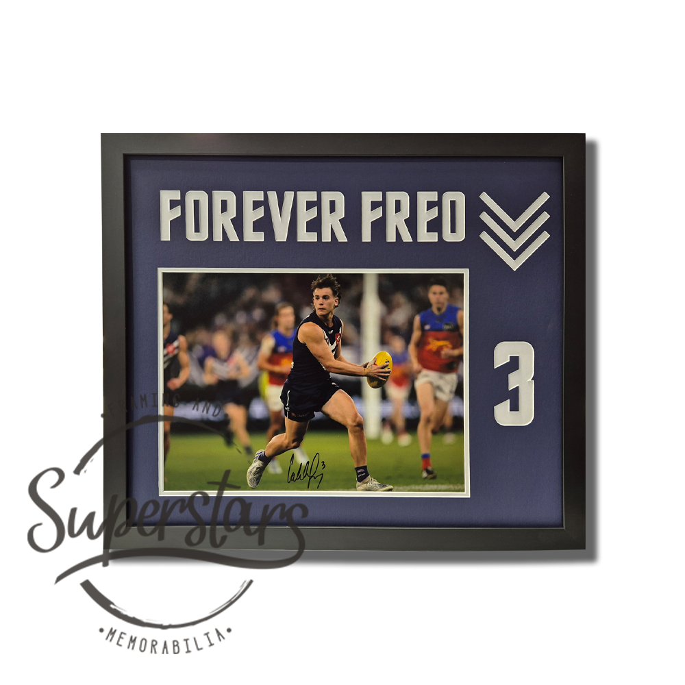 A large photo of Caleb Seron during a game. The photo is surrounded by a thin white border, and a largers dark purple border. The dark purple border has the words Forever Freo cut into it across the top, the Freo dockers arrows and Caleb's jumber number 3.