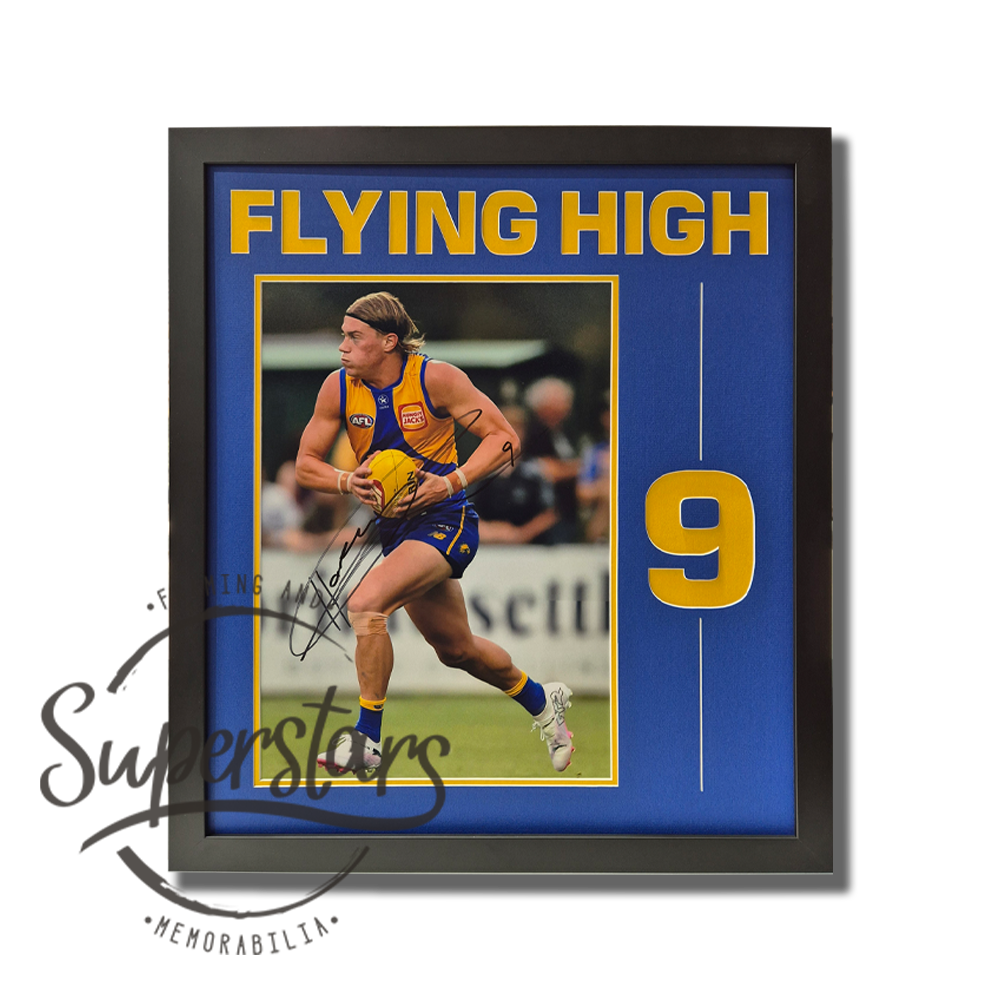 Harley Reid Memorabilia. To the left is a large close up photo of Harley running with the ball during a game. This photo is surrounded by a thin yellow border. Alongside the photo is the number 9 cut into the matting so it is also yellow. The words Flying High are cut into the top as a title. The main border is royal blue.