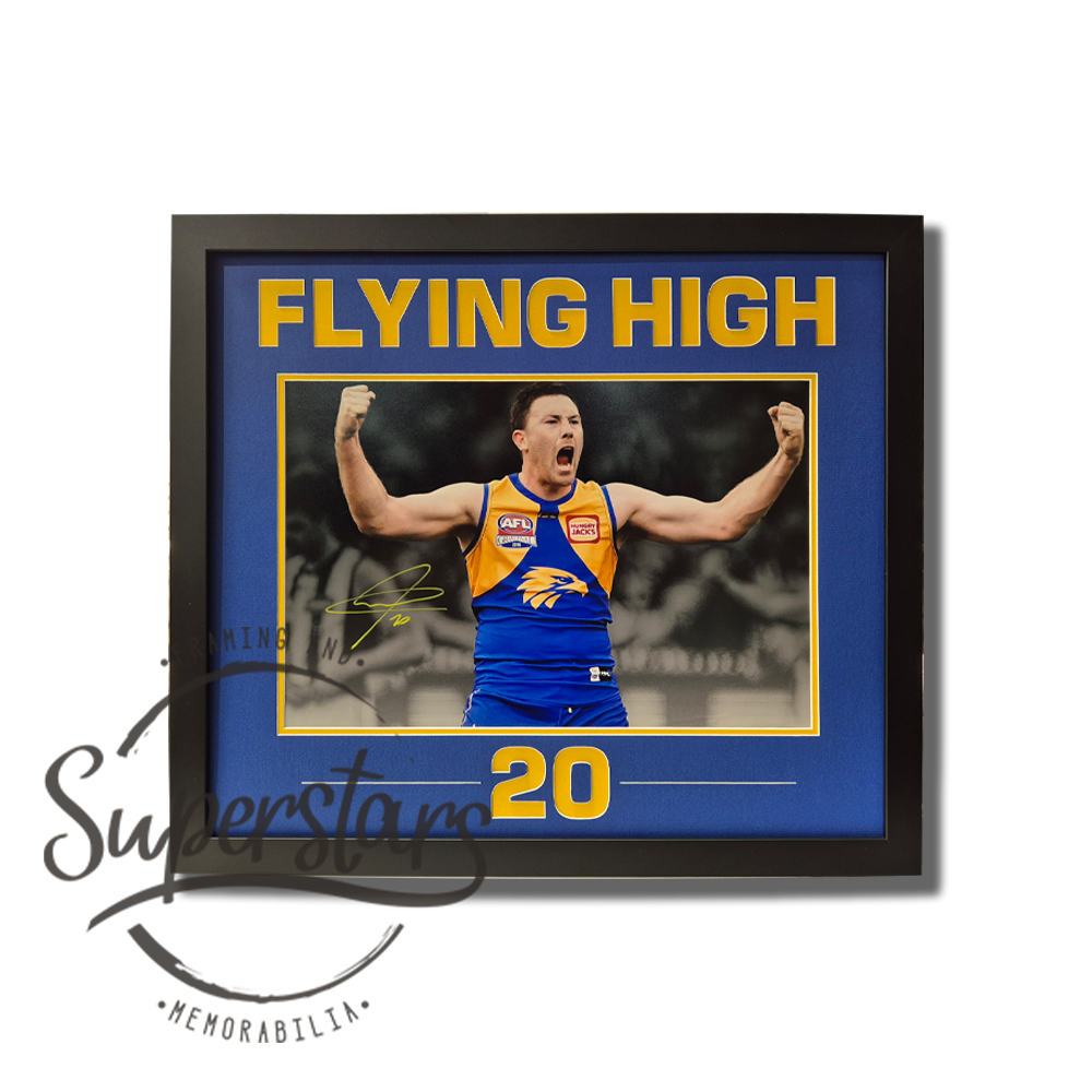 Jeremy McGovern Memorabilia. Large photo of Jeremy celebrating with this arms punching the air. It is surrounded by a thin yellow border, and a wide blue border. Below the photo the number 20 is cut out which makes it yellow. The words Flying High are cut into the top as a title. The main border is royal blue.